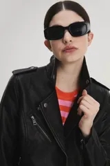 Campera de cuero sintético negra, estilo motociclista, con cierre asimétrico, cuello con solapas y múltiples bolsillos con cierre.