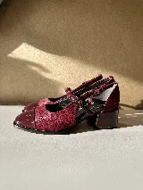 Zapato tipo ballerina color borgoña, con puntera charolada, hebilla lateral y taco cuadrado.