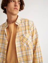 Camisa de manga larga confeccionada en tela de algodón, con bolsillo en el pecho y botones de pasta, diseño clásico y logo en el bolsillo.