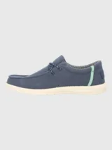 Alpargata negra con cordones elásticos y suela blanca con textura.