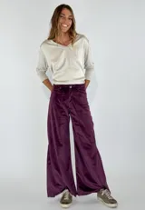 Pantalón de terciopelo color borgoña, de corte palazzo con bolsillos laterales.