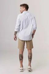 Camisa blanca de corte slim fit, manga larga y cuello clásico. Cierre frontal con botones.