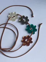 Gargantilla con cordón marrón y cuatro dijes de flores de acrílico transparente, gris, verde y naranja.