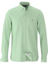 Camisa Tommy Hilfiger de corte slim, color verde claro, confeccionada en tejido dobby de algodón orgánico con tecnología TH Flex. Presenta cuello abotonado, puños redondeados con dos botones y logo bordado en el pecho.