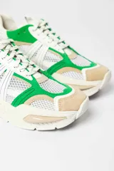 Zapatillas deportivas de malla blanca con superposiciones de cuero color beige y verde. Suela gruesa de goma color hueso.