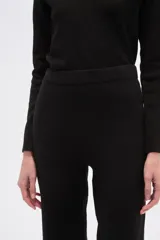 Pantalón de tejido de punto con tiro alto y calce ancho, presentando un estampado pixelado o camuflado en tonos marrón, beige y blanco.