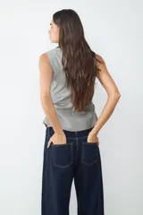 Top sin mangas con escote pico, frunce delantero y bajo ligeramente abierto.