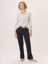 Pantalón de vestir color marrón, corte cigarette (pierna angosta) con tajo en el bajo. Presenta una cintura elástica ancha de color beige claro.