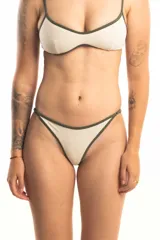 Bombacha less forrada de color crudo, con laterales regulables mediante tiritas finas.