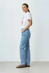 Jean de denim celeste, de corte recto, tiro medio y largo hasta el tobillo.