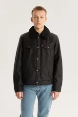 Campera trucker de cuero sintético color negro con cuello de sherpa negro, cierre con botones metálicos, bolsillos con solapa en el pecho y bolsillos laterales.