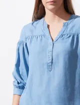 Blusa celeste de lyocell con cuello a la base, escote en V con botones y mangas 3/4 con puño abotonado.