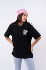 Remera negra de corte oversize con estampado frontal que dice "MIJA DREAM BIG" en tipografía blanca y rosa.