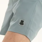 Short de baño liso color celeste, con cintura elastizada y cordón ajustable.