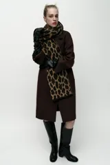 Bufanda rectangular color marrón con estampado de leopardo y flecos cortos en los extremos.