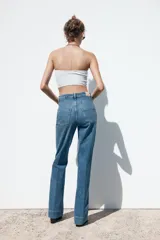 Pantalón de jean de tiro alto con bolsillos frontales y traseros. Corte recto y cierre frontal con cremallera y botón.