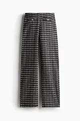 Pantalón ancho de punto bouclé a cuadros en tonos grises y blancos, con cintura elástica y bolsillos decorativos con botón dorado.