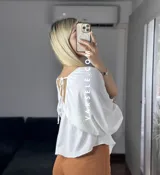 Blusa verde agua con escote en V, mangas cortas abullonadas y tiritas para atar.