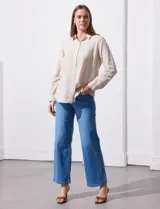 Camisa color beige de lino, marca Dash. Tiene cuello con solapa, abertura central con botones, bolsillo aplicado en el pecho y mangas largas regulables con presilla y botón.