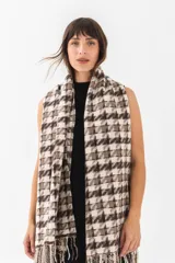 Bufanda larga color crudo con estampado de cuadros negros y flecos en los extremos.