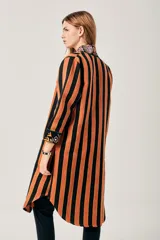 Saco largo con estampado de flores y rayas verticales en tonos naranja, verde y negro.