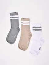 Pack de tres pares de medias de algodón de caña media, con dos rayas horizontales en el puño y logo de la marca en el tobillo. Un par es gris con rayas blancas, otro beige con rayas blancas y el tercero blanco con rayas grises.