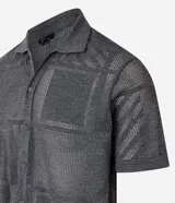 Camisa de punto gris con cuello inglés, mangas cortas, abotonadura frontal y textura geométrica.