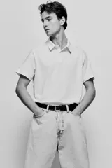 Remera polo blanca de punto de algodón liviano, corte slim fit, con cuello, tapeta de botones y bajo recto.