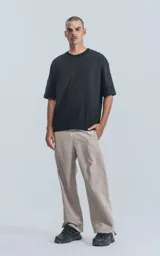 Remera negra de algodón premium, corte crop y oversize, con hombros caídos y cuello redondo.