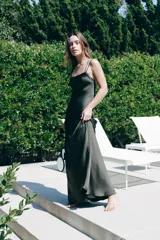 Vestido largo de tirantes finos cruzados en la espalda, confeccionado en tejido satinado color verde oscuro.