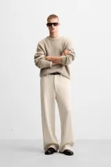 Pantalón largo color beige confeccionado en pana de algodón, de corte wide fit, con bolsillos frontales y traseros.