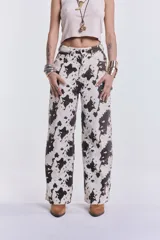 Pantalón de denim de corte wide leg con estampado de manchas de vaca.