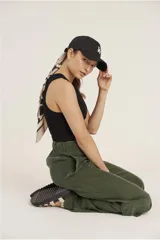 Pantalón de calce ancho y fluido en color negro, confeccionado en tejido de cupro. Presenta bolsillos laterales tipo cargo y un diseño de tiro alto.