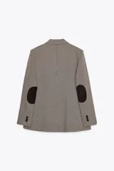 Blazer de cuello solapa y manga larga con estampado de pata de gallo en tonos marrones y negros. Bolsillos de vivo en delantero, detalle de coderas a contraste y cierre frontal con botón.