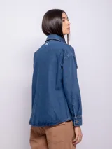 Sobrecamisa de denim azul con mangas largas, bolsillos frontales y botones metalizados.
