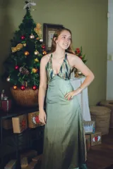 Vestido largo color marrón cobrizo con escote en V, cut outs laterales bajo el busto y breteles finos que se cruzan y atan en la espalda. Presenta un top con estampado abstracto en tonos marrones y dorados.