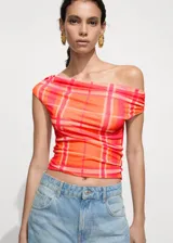 Top de mangas cortas con estampado de cuadros en tonos naranja y rosa, con cuello barco y hombro descubierto. Diseño crop y entallado de tejido elástico.