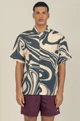 Camisa de manga corta con cuello tipo camp, con estampado abstracto en tonos beige y negro.