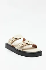 Sandalias marrones con plataforma baja y tiras anchas con hebillas metálicas.