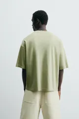 Camiseta verde oliva de corte holgado, cuello redondo y manga corta.