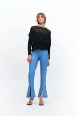 Calza negra de tiro alto con textura acanalada y aberturas en el ruedo.