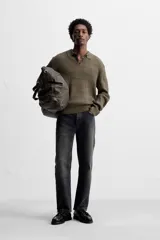 Polo color verde oliva de corte regular, tejido de punto con mezcla de algodón y cashmere. Tiene cuello solapa con cierre frontal de botonadura, manga larga y acabados en rib.