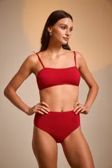 Conjunto de bikini rojo con textura brillante, compuesto por un corpiño bandeau con tirantes finos y una bombacha de tiro alto.