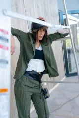 Blazer verde con rayas verticales blancas, solapas clásicas y corte entallado.