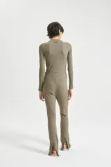 Pantalón largo de morley color verde oliva, con calce ajustado, tiro medio, cintura con elástico interno, ruedo con tajo en la parte posterior y cierre metálico.