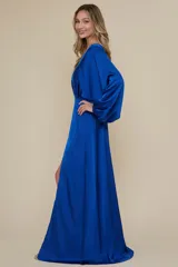 Vestido largo de satén color azul eléctrico, con mangas largas abullonadas y abertura lateral en la falda.