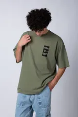 Remera verde militar de corte oversize con estampado negro en el frente.