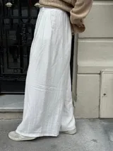 Pantalón sastrero negro de corte palazzo, con botón, pasacinto y pretina trasera con elástico.