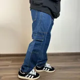 Pantalón de jean azul, corte recto, con bolsillos cargo laterales.