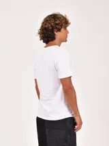 Remera de manga corta color verde oliva, con cuello redondo y un bolsillo frontal en el pecho.